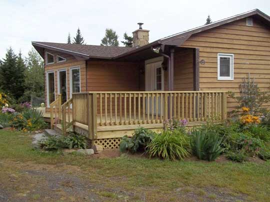 New wraparound deck with railing added to existing home. Work by Mark Oickle Construction.