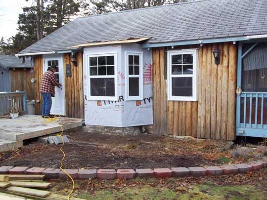 Renovation of heritage Caledonia split log siding cottage: new bay window added.