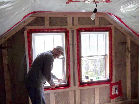 Inside the cape Co home, upstairs installing news windows in newly insulated walls.