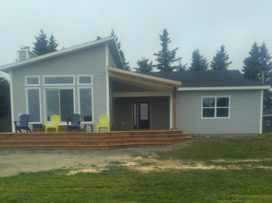 Completed house with extensive deck wrapping around the house