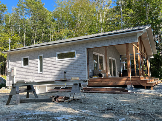 Nearly completed cottage with deck surrounded by steps for easy ground access