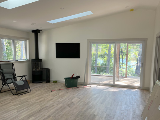 Bright, huge living room with wood stove, skylights, sliding doors