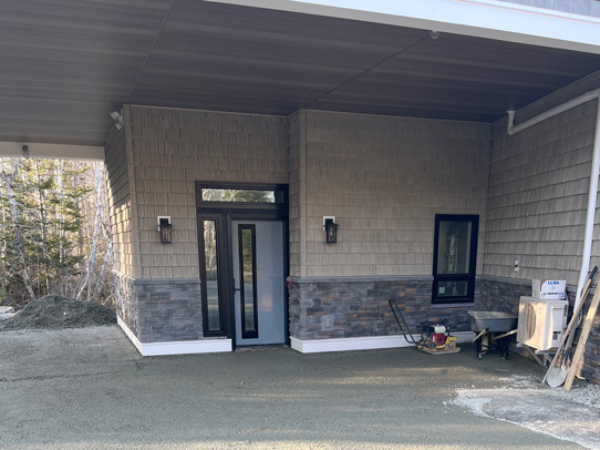 Closeup view of new entrance door under second floor addition